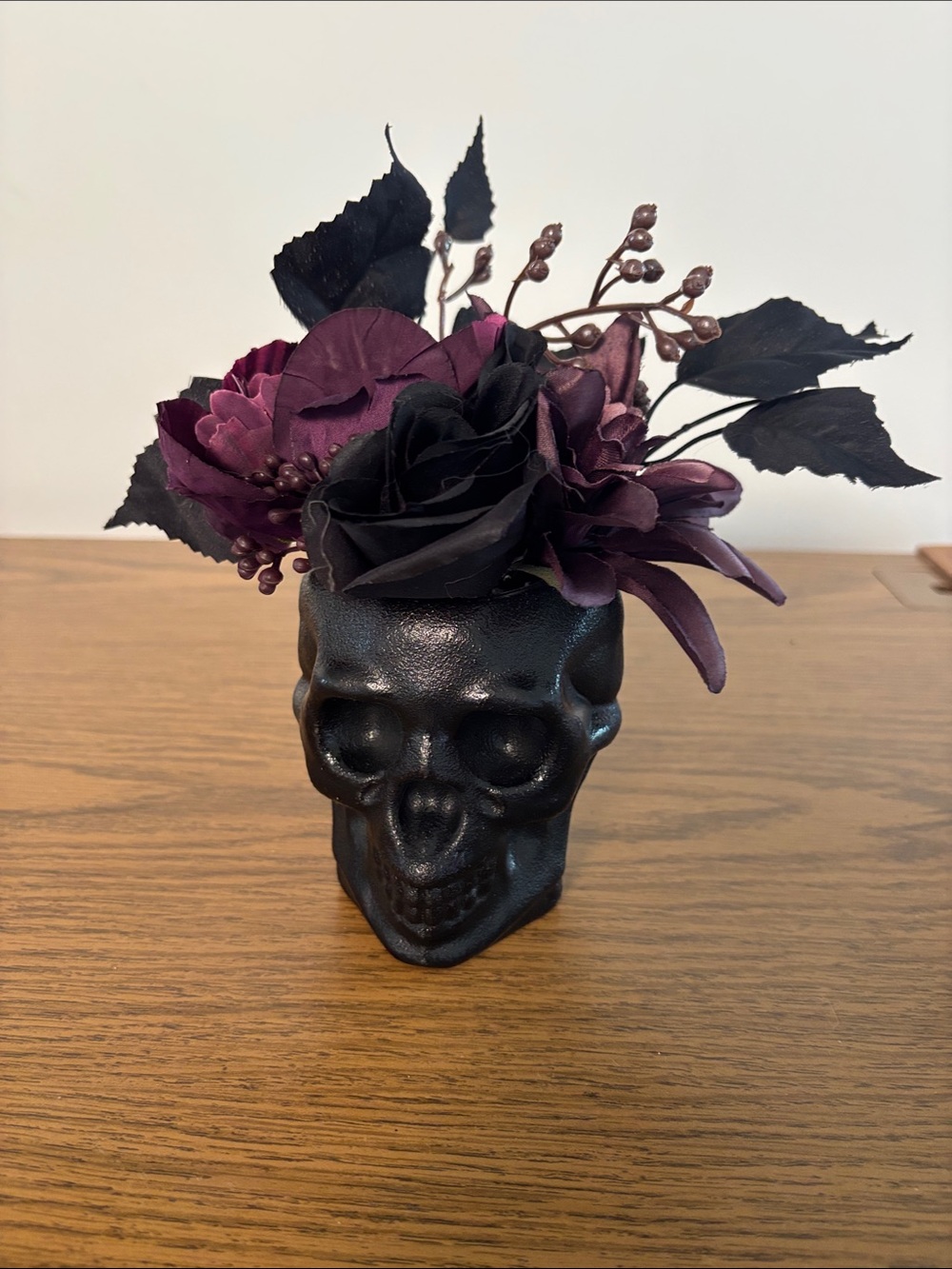 Black Skull Vase with Dark Purple Floral Arrangement